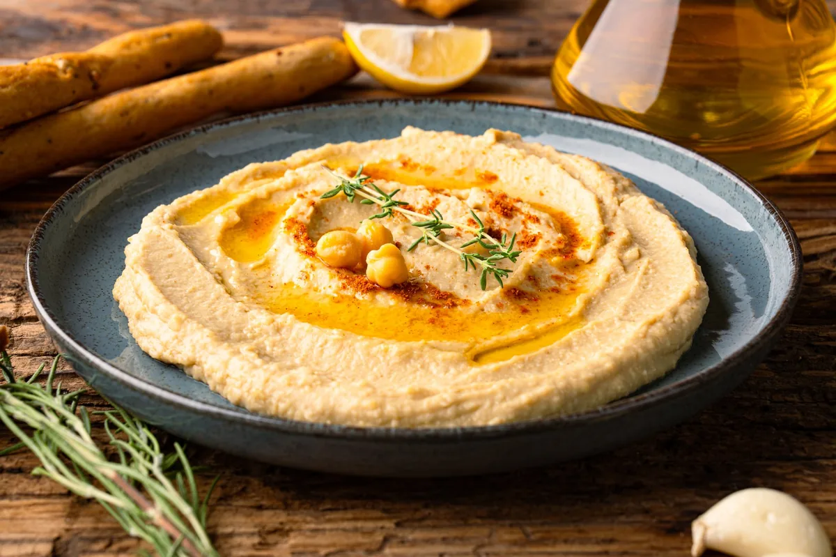 A traditional dish or appetizer hummus or baba ghanouj on wooden background